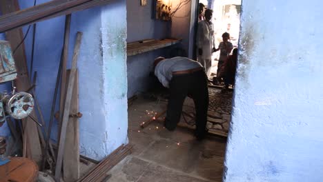 Welder-at-work-with-blowtorch-in-house-and-children-watching-with-curiosity