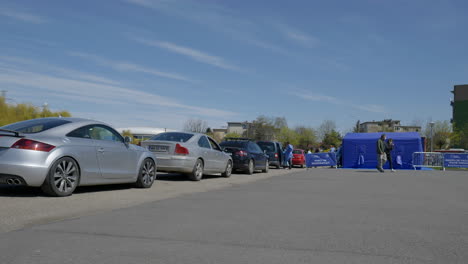 Static-wide-shot-from-the-back-of-a-big-queue-of-cars-where-people-are-waiting-their-turn-to-get-the-Pfizer-BioNTech-vaccine-in-the-second-drive-through-COVID-19-vaccination-center-in-Romania