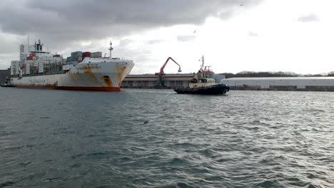 Schlepper-Hilft-Riesigen-Alten-Und-Rostigen-Containerschiff-Im-Hafen-Von-Antwerpen