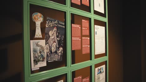 Vintage-chocolate-advertisements-and-historical-documents-displayed-in-a-green-framed-case-at-Zagreb's-Chocolate-Museum