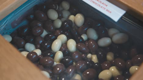 Close-up-of-a-mix-of-white-and-dark-chocolate-coated-almonds-in-a-display-case-at-Zagreb's-Chocolate-Museum