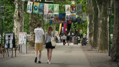 La-Gente-Caminando-Por-Un-Sendero-Arbolado-Decorado-Con-Coloridas-Banderas-En-El-Cest-De-Zagreb-Es-El-Mejor-Festival-Callejero