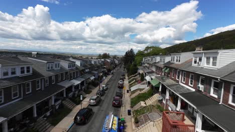 Aerial-fpv-flight-over-narrow-street-with-parking-cars-in-housing-area-located-on-hill