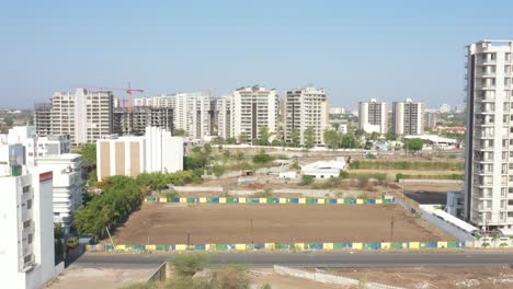 Drone-camera-moving-upwards-showing-tall-buildings-and-large-schools-across-a-farm