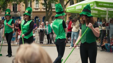 Un-Grupo-De-Artistas-Vestidos-Con-Trajes-Y-Sombreros-Verdes,-Bailando-Con-Escobas-En-El-Cest-De-Zagreb-Es-El-Mejor-Festival-Callejero.