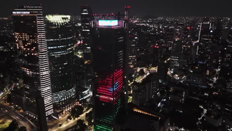 Night-aerial-view-of-colorful-corporate-skyscrapers-and-lights-of-Mexico-City