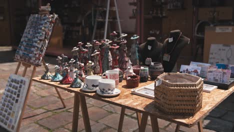 table-at-Varaždin's-Market-of-Traditional-Crafts-displaying-handmade-ceramics,-figurines,-mugs,-necklaces,-and-postcards