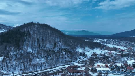 Eine-Luftaufnahme-Eines-Schneebedeckten-Bergresorts-Mit-Skipisten,-Hütten-Und-Einrichtungen,-Das-Ein-Perfektes-Winterurlaubsziel-Darstellt