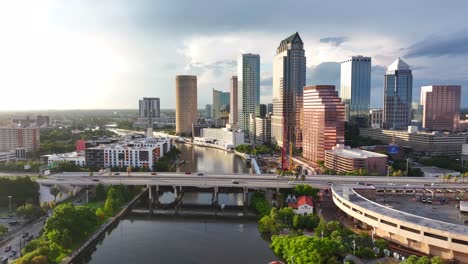 Downtown-Tampa,-Florida-skyline-at-golden-hour-with-bridges-and-bustling-traffic-over-the-Hillsborough-River