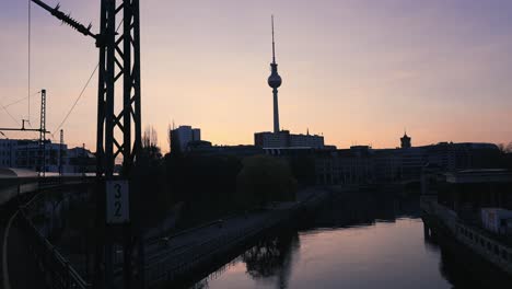 Berlin-Fernsehturm-at-sunrise,-Unique-train-exterior-view-of-Berlin's-television-tower-during-sunset