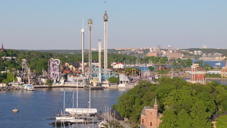 Aproximación-Aérea-Con-Teleobjetivo-Hacia-El-Parque-De-Atracciones-Gröna-Lund-En-Estocolmo,-Suecia