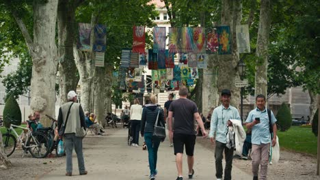 Menschen,-Die-Auf-Einem-Von-Bäumen-Gesäumten-Weg-Spazieren,-Der-Mit-Bunten-Bannern-Geschmückt-Ist,-Beim-Straßenfest-Cest-Is-D&#39;best-In-Zagreb