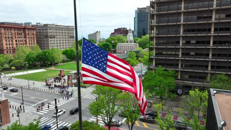 American-flag-waving-in-front-of-Independence-Hall-in-historic-Philadelphia,-Pennsylvania