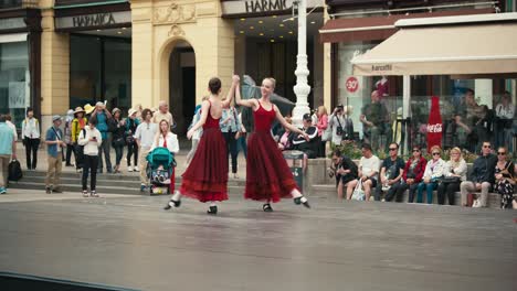 Two-ballet-dancers-in-red-dresses-performing-on-an-outdoor-stage-in-front-of-an-audience-at-Zagreb's-Cest-is-d'Best-street-festival