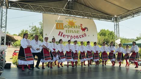 Bulgarian-folk-group-in-costume-perform-energetic-dance-on-outdoor-stage