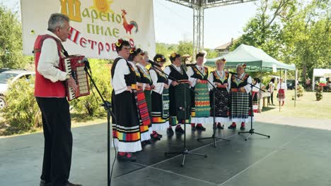 Bulgarische-Damenvolkschorgruppe-Singt-Bei-Open-Air-Festival-Mit-Akkordeonmusiker