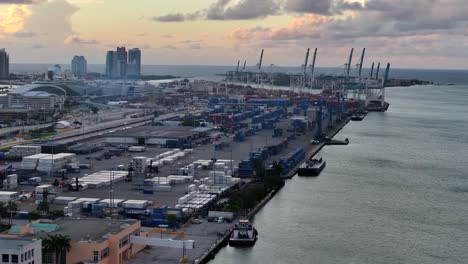 Port-of-Miami-with-cargo-containers,-shipping-cranes,-and-docked-ships-during-sunrise