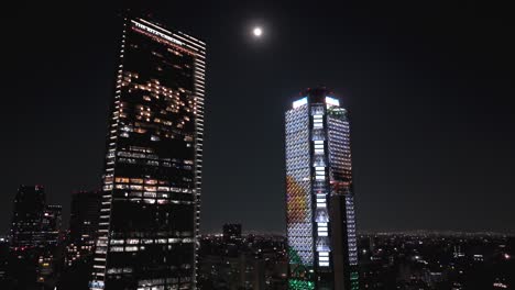 Flying-through-colorful-corporate-skyscrapers-and-lights-over-congested-avenue-in-Mexico-City