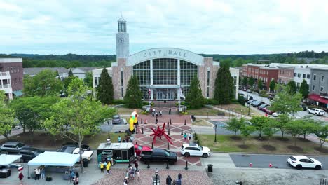 Aerial-approaching-shot-of-City-Hall-in-Suwanee-City-with-american-flag