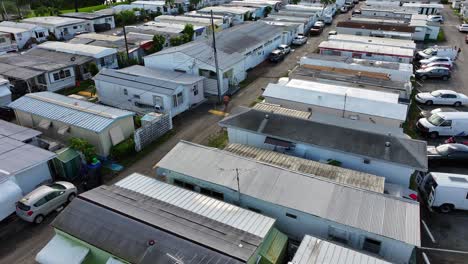 Drone-footage-of-a-mobile-home-park-in-Hallandale-Beach,-Florida,-with-densely-packed-trailers,-narrow-streets,-and-parked-vehicles