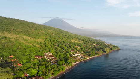 Where-land-meets-embrace-of-the-sea,-the-Balinese-coast-unfolds,-aerial