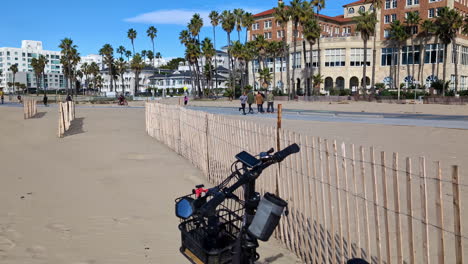 Slow-motion-view-on-a-pedestrian-path-on-the-Venice-Beach-with-palm-trees-and-a-blue-sky,-copy-space