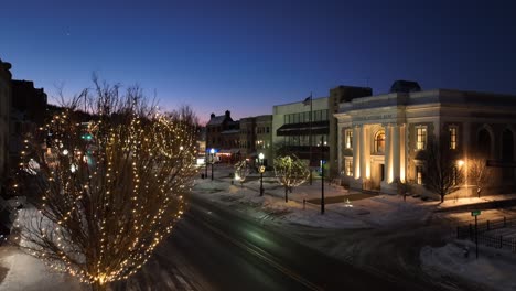 Lighting-Lantern-in-snowy-city-with-waving-american-flag-at-dusk