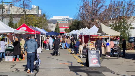 Gente-Navegando-Por-Varios-Puestos-En-Un-Animado-Mercado-Al-Aire-Libre-En-Oakland,-California