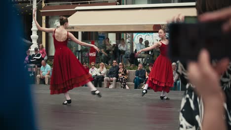 Dos-Bailarinas-De-Ballet-Con-Vestidos-Rojos-Actuando-En-Un-Escenario-Al-Aire-Libre,-Con-Una-Audiencia-Mirando,-En-El-Cest-De-Zagreb-Es-El-Mejor-Festival-Callejero