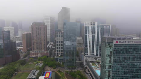 Aerial-tracking-shot-of-the-Marriott-marquis-hotel-and-condos-in-foggy-Houston