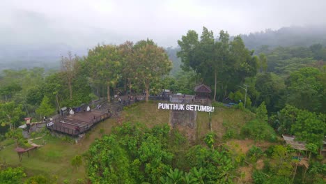 Aerial-view-of-tourist-attraction-is-called-"Punthuk-Setumbu"-at-the-top-of-the-hill-with-the-words-"Punthuk-Setumbu"-in-the-morning