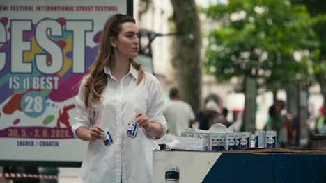 Woman-handing-out-drinks-at-a-booth-during-Zagreb's-Cest-is-d'Best-street-festival