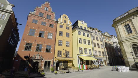 Famosas-Casas-Coloridas-Del-Casco-Antiguo-O-Gamla-Stan-Apiladas-Una-Al-Lado-De-La-Otra-Con-Fachada-Amarilla-Y-Naranja