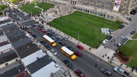 School-buses-and-students-leaving-public-high-school-in-American-city,-Reading,-Pennsylvania