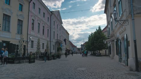 Scenic-view-of-Franciscan-Square-in-Varaždin,-Croatia,-featuring-historic-buildings,-cobblestone-streets,-and-people-walking