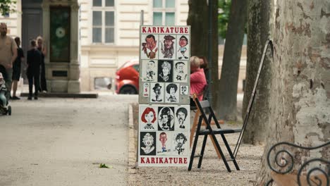 Caricature-artist's-display-board-and-chairs-set-up-in-a-park-during-Zagreb's-Cest-is-d'Best-street-festival