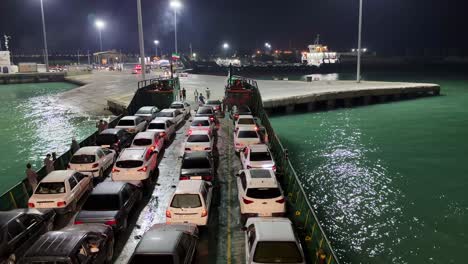 Landungsboot,-Kommerzielles-Boot,-Das-Fahrzeuge-Transportiert,-Nachts,-Schwimmt-Auf-Grünem-Wasser,-Hafen,-VAE,-Seeverkehr,-Nachtschifffahrt,-Vereinigte-Arabische-Emirate,-Transport,-Wasserstraßen,-Grünes-Meer,-Lebhafter-Hafen,-Iranische-Landschaft