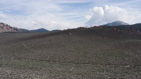 Amplia-Vista-De-La-Montaña-Del-Cráter-Y-Las-Colinas-Eólicas-Con-Cielos-Despejados-Y-Montañas-Distantes.