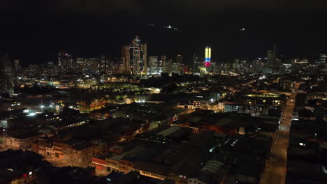 AERIAL:-Bogota-city-skyline-in-colorful-night-lights,-evening-darkness-in-Colombia