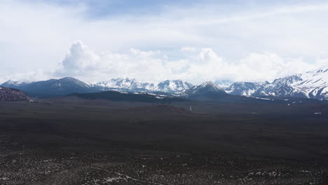 Montañas-Cubiertas-De-Nieve-Y-Vastas-Llanuras-Bajo-Un-Cielo-Nublado