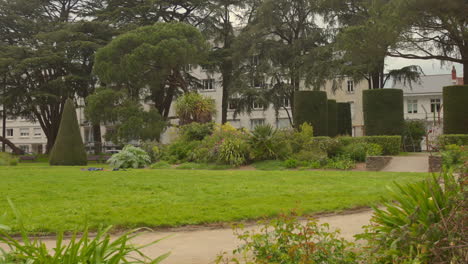 Shot-of-green-vegetation-covering-empty-Square-Maurice-Schwob-Park-in-Nantes,-France-on-a-cloudy-day