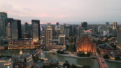 Warmes-Licht-Spiegelt-Sich-Im-Flusswasser-Von-Hotelgebäuden-Und-Büros-In-Shanghai,-China