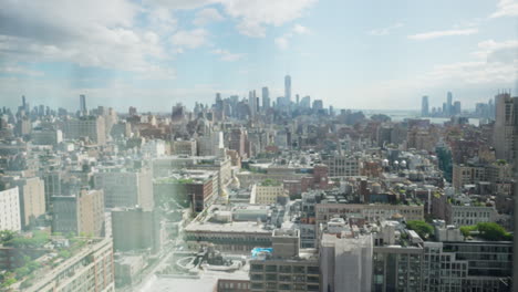 Hand-slowly-opening-window-blind-revealing-the-skyline-view-of-Manhattan