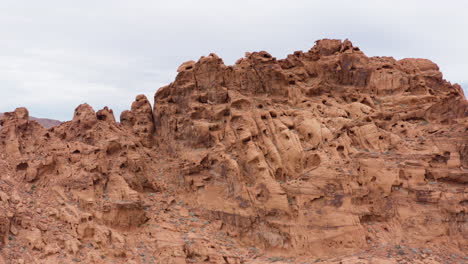 Copy-space-aerial-shot-of-the-rocky-formation-on-one-of-the-Red-Sandstone-hills-with-the-valley-in-the-background