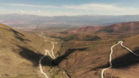 Vista-Panorámica-Desde-Un-Dron-De-La-Subida-Conocida-Como-Cuesta-De-Aparzo,-Que-Conduce-Al-Hornocal-O-Cerro-De-Los-14-Colores,-Con-El-Pintoresco-Pueblo-De-Humahuaca-Al-Fondo