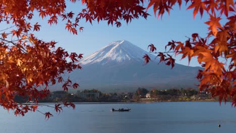 Mount-Mt-Fuji-View-through-Red-Maple-Leaves-in-peak-Autumn-with-Fisher's-Boat-on-Lake-Kawaguchiko