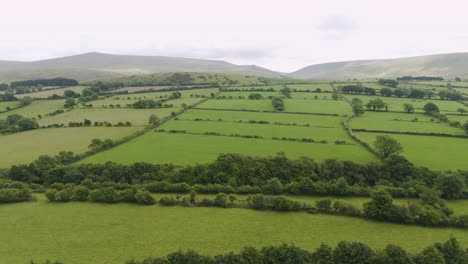 Aerial-view-revealing-the-expansive-landscape-of-Dartmoor-in-Devon-UK,-showcasing-fields,-hills,-and-rural-scenery