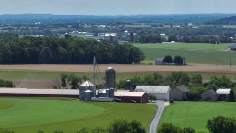 Aerial-wide-shot-of-farm-with-Silo-and-barn-in-rural-area-of-USA