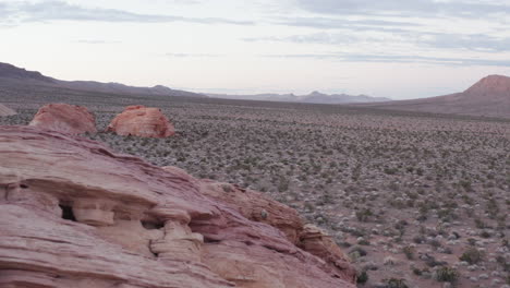 Sobrevuelo-Cinematográfico-De-Drones-Junto-A-Una-Gran-Formación-Rocosa-Roja-En-Red-Stone,-Nevada,-EE.-UU.