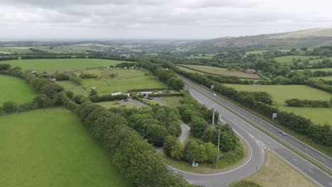 Aerial-view-of-the-A30-in-rural-Devonshire-countryside-UK,-featuring-fields,-greenery,-and-traffic